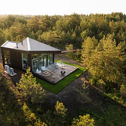 Modern outdoor living space with the contemporary Mix 850 fire pit creating warmth and atmosphere on a patio beside a glass-walled home
