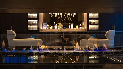 EcoSmart Fire Linear 65 Fire Pit Kit enhances a private residence with a sleek built-in ethanol fireplace for living and bar areas.